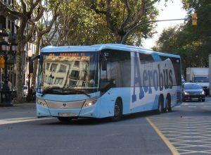 Aerobus from Barcelona Airport A blue and white Aerobus driving in the streets of Barcelona.