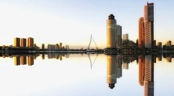 Lots of tall buildings reflected on the water creating a mirror image.