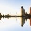 Lots of tall buildings reflected on the water creating a mirror image.