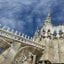 View of the Duomo in Milan city centre, with cloudy blue skies above.
