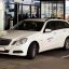 A white Vienna taxi parked outside the airport.