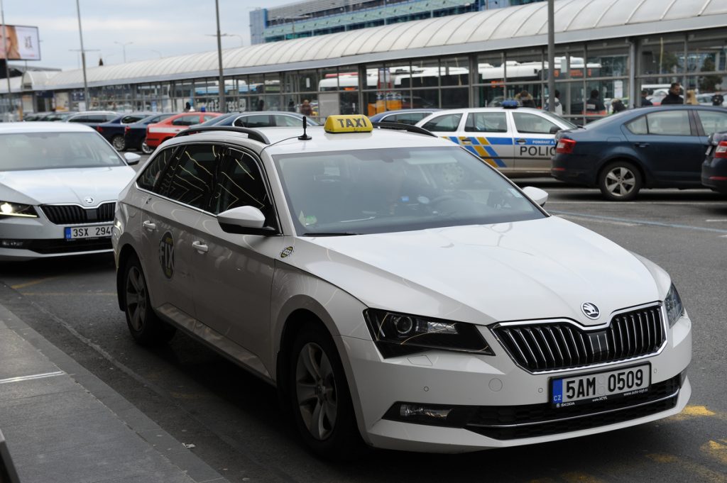Close up of a white Prague Airport taxi queueing in the taxi rank outside of the airport.