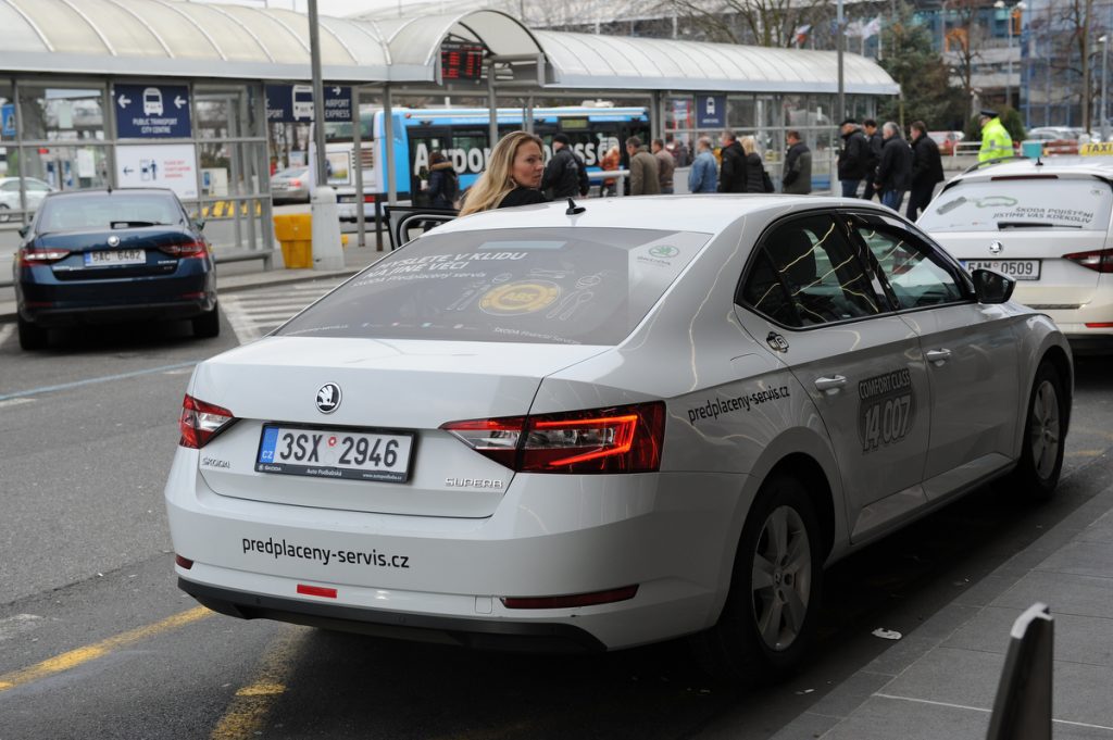 Rear view of a white Prague Airport taxi in the taxi rank outside of the terminal.