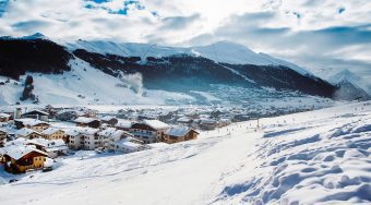A mountain range covered in snow with a small village at the base