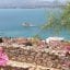 View from above the town of Nafplio overlooking the sea, with pink flowers on the side.