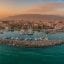 An orange-tinted sky glows over Kalamata, creating a warm sense on the tranquil waters and boats below. Arrange your transfer from Kalamata Airport to the city center to experience this picturesque view effortlessly.