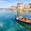 Mytilene bay with building ruins and a small boat.