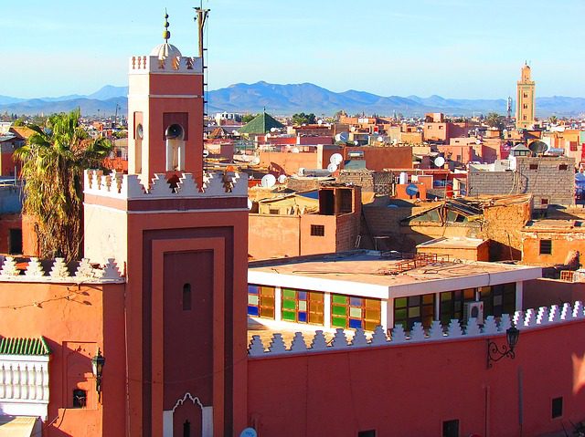 City skyline with mountains framing a city landscape with buildings in the sun