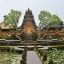 View of Ubud Royal Palace, surrounded by lush green trees and vegetation.