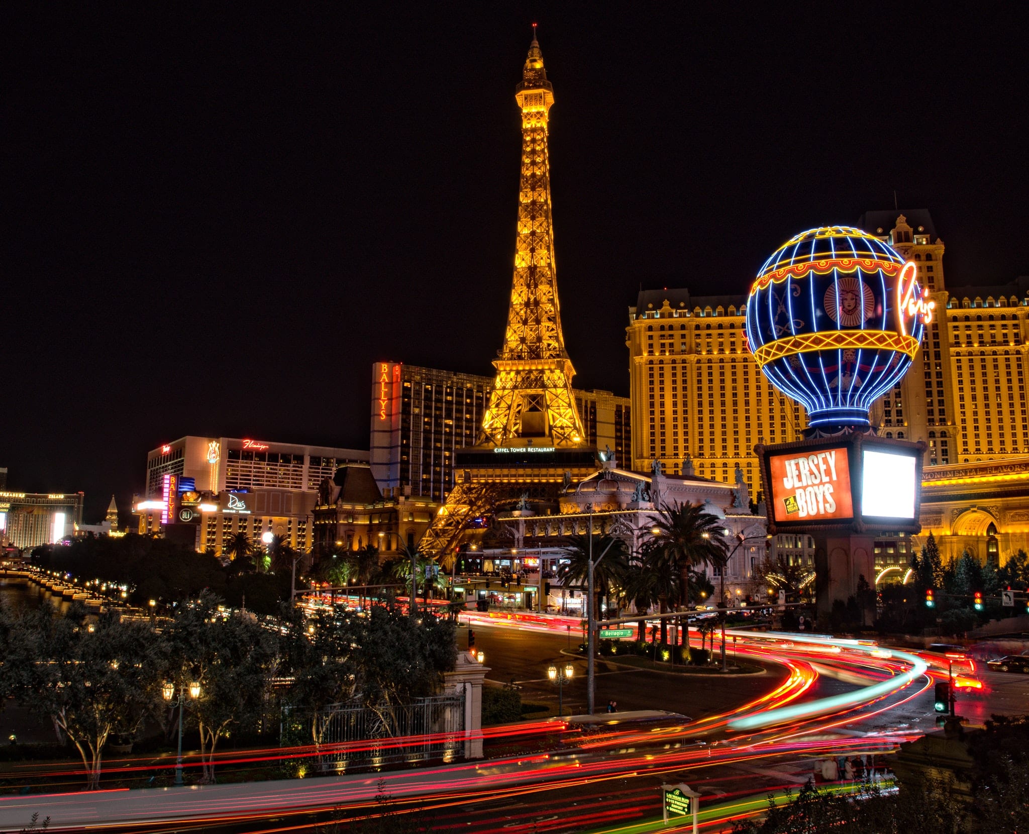Las Vegas Strip at night with the Eiffel Tower in view.