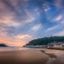 Scenic view of San Sebastián’s coastline at sunset, with calm waves, a sandy beach, and Monte Igueldo in the background—typical arrival sights when traveling from Bilbao Airport to San Sebastián.