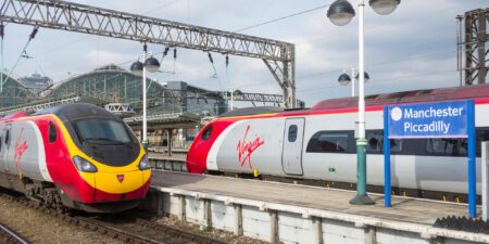 Two trains red and silver trains passing each other at Manchester Piccadilly Train Station.