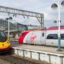 Two trains red and silver trains passing each other at Manchester Piccadilly Train Station.
