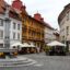 white, mustard and brown concrete buildings with red brick roofs near city centre with busy cafes
