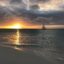 sea view wih a sailboat heading towards the sunset at Eagle Beach in Aruba
