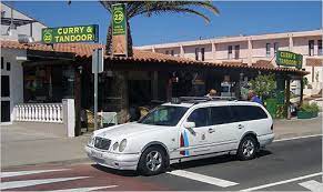 white station wagon car with dark blue and light blue stripes on front door operating as taxi in Fuerteventura