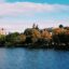 Inverness castle in distance surrounded by green and yellow leaf trees near body of water in daytime