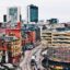 aerial shot of Manchester city with modern and old buildings, car parks, shopping malls offices and traffic featured