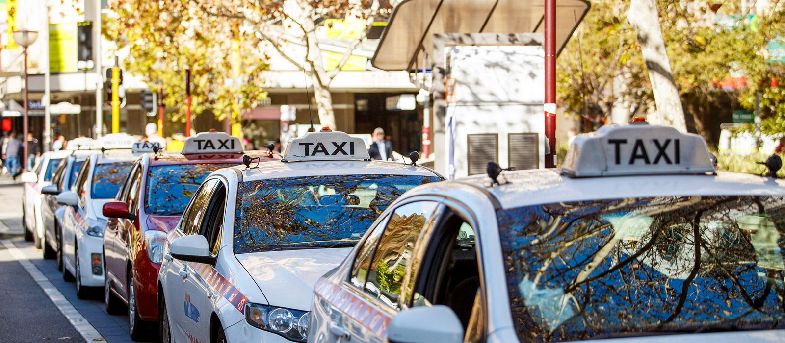 Perth taxis white and red taxis lining up at a taxi rank in Perth, with their signature TAXI signage