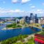daytime photo of downtown Pittsburgh from the top of Duquesne Incline, with tall city buildings, blue waters and yellow brigdes standing out