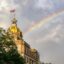 shot of the Savannah city hall's top, half covered by a green tree under a cloudy sky, right after thunderstorm, with a vivid rainbow