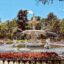 The famous fountain in Forsyth Park, surrounded by an iron gate and oak trees.