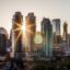 sun shining over modern high city buildings