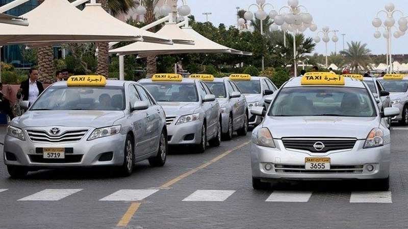 silver taxis with swignature yellow roof sign