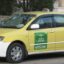 yellow taxi with white bottom part with white sign on its roof and black letters