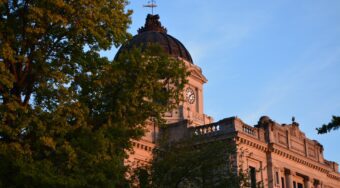courthouse appearing behind a green tree during golden hour