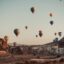 hot air baloons going up the sky in daytime