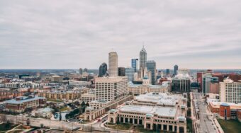 aerial shot of city buildings under a cloudy sky in daytime