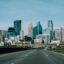 daytime photo of motorway and high rise city buildings