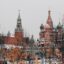 The Moscow Kremlin photographed on a snowy day with some orange leaf trees in front of it