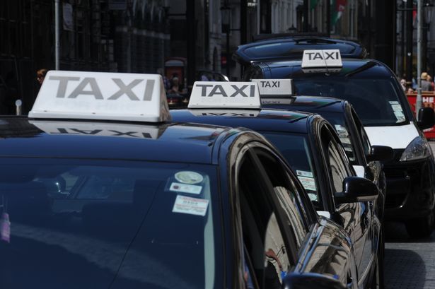 black taxis with signature white and black roof sign lining up in a cab rank