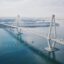long white bridge connecting two bits of land spreading over body of water