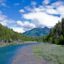 Alaska wilderness by a river or stream with green and blue mountains in background.