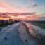 sun setting over the beach creating a breath-taking sky feauturing blue, pink and orange hues