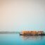 boat sailing in milky blue body of water during daytime