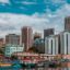 large colourful boats in body of water near mid rise colourful city buildings and hotels