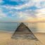 wooden dock path going into the calm sea waters under a cloudy sky in daytime