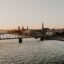 bridge over body of water in Riga, photographed around golden hour with city buildings in the background