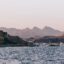 ferries in the sea near mountains and rocky formations during the day