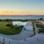 sun rising in Zadar, summer resort with green grass and trees, swimming pool and sun loungers by body of water