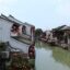 white cottages with concrete stairs and brown roofs on each side of a river