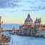 View of domed buildings and low-rise city buildings lining the Venice canal