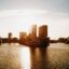 sunset photo of city buildings by body of water