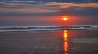 Sunset at a beach in Seminyak with the waves hitting the shore.