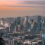 aerial photograph of city buildings and modern skyscrapers as the sun sets over the city