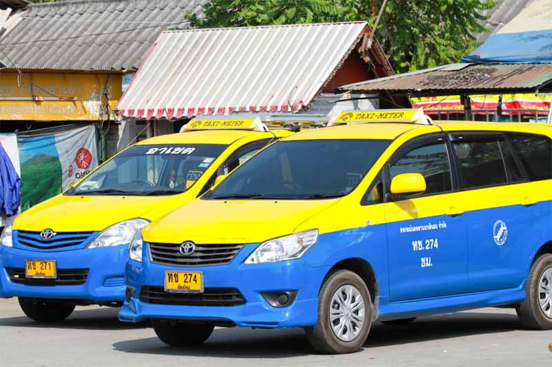 two yellow and bright blue taxis with a signature roof sign in yellow